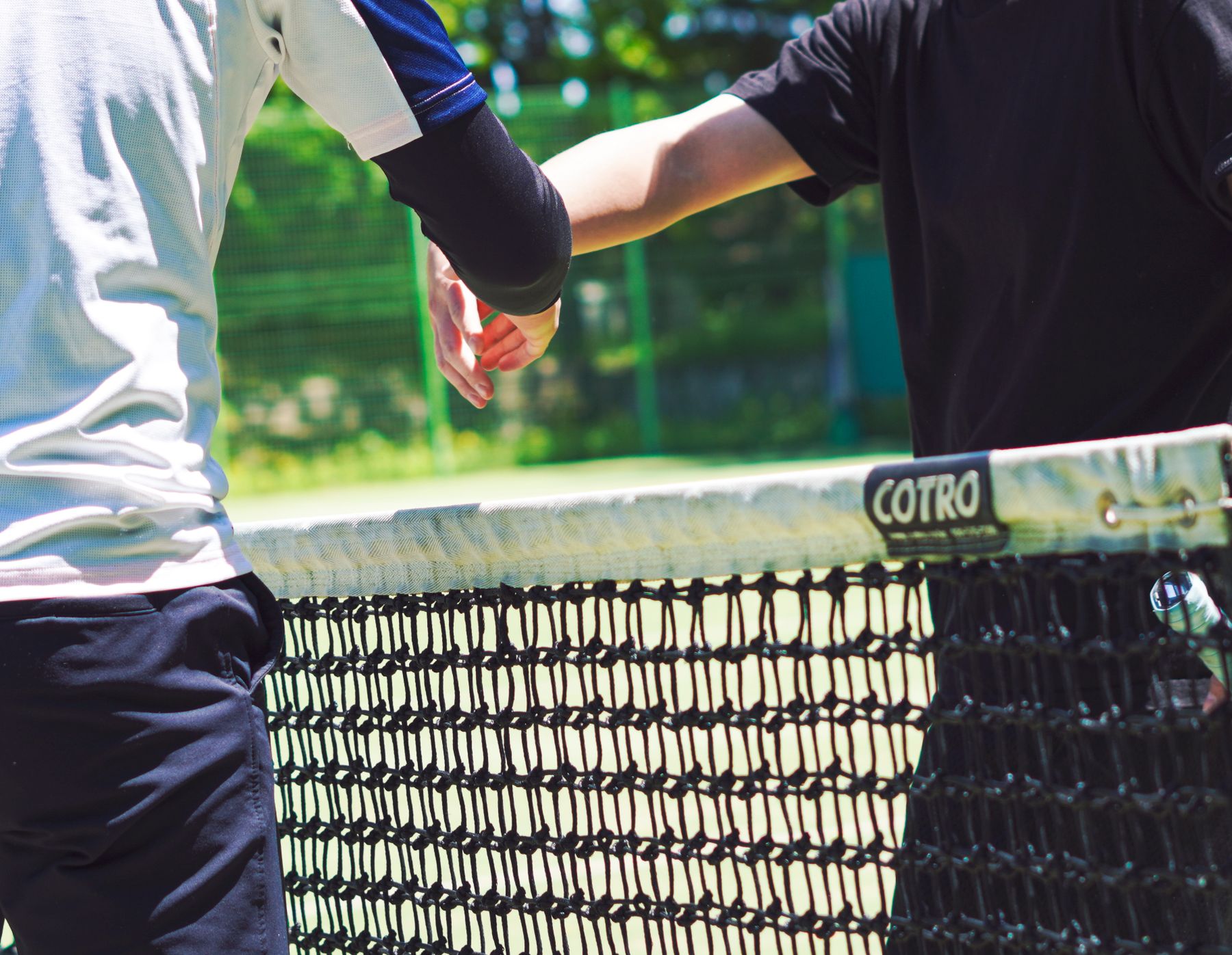Coach and student meeting at the net after a lesson